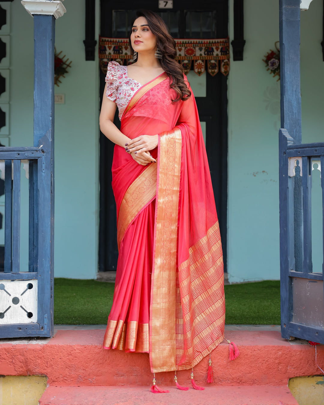 Vibrant Coral Pink Plain Chiffon Saree with Gold Zari Border, Floral Ruffled Blouse & Tassel Detailing