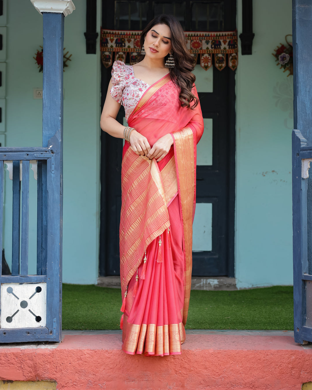 Vibrant Coral Pink Plain Chiffon Saree with Gold Zari Border, Floral Ruffled Blouse & Tassel Detailing