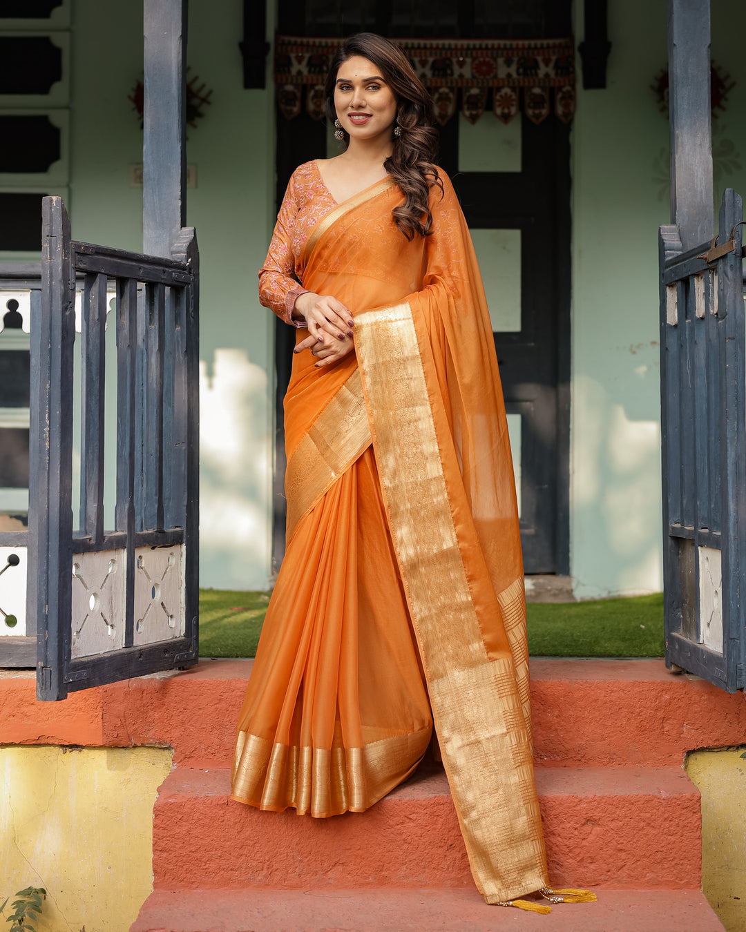 Sunset Orange Plain Chiffon Saree with Gold Zari Border, Floral Embroidered Blouse & Tassel Detailing